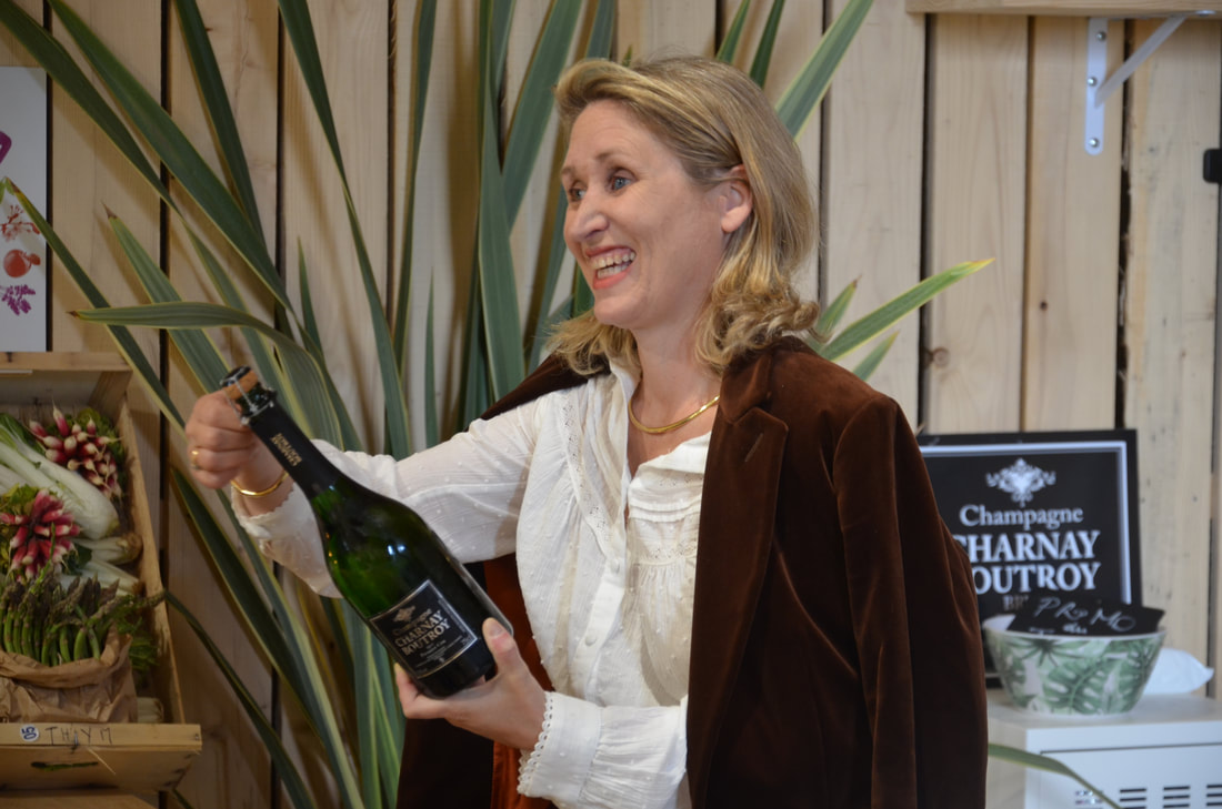 Céline Charnay-Boutroy, vigneronne, une bouteille de Champagne Charnay Boutroy à la main